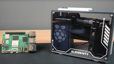 Michael Klements' custom Raspberry Pi 5 case with Pi 5 open loop rebuilt within hyper compact case, beside a regular Pi 5.